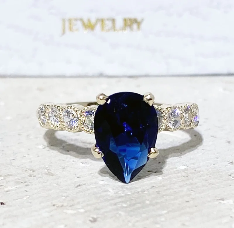 Emerald Gemstone Rings with Filigree - Bordered SettingsBlue Sapphire Ring - September Birthstone - Statement Engagement Ring with Pear-Shaped Blue Sapphire Gemstone and Clear Quartz Accents